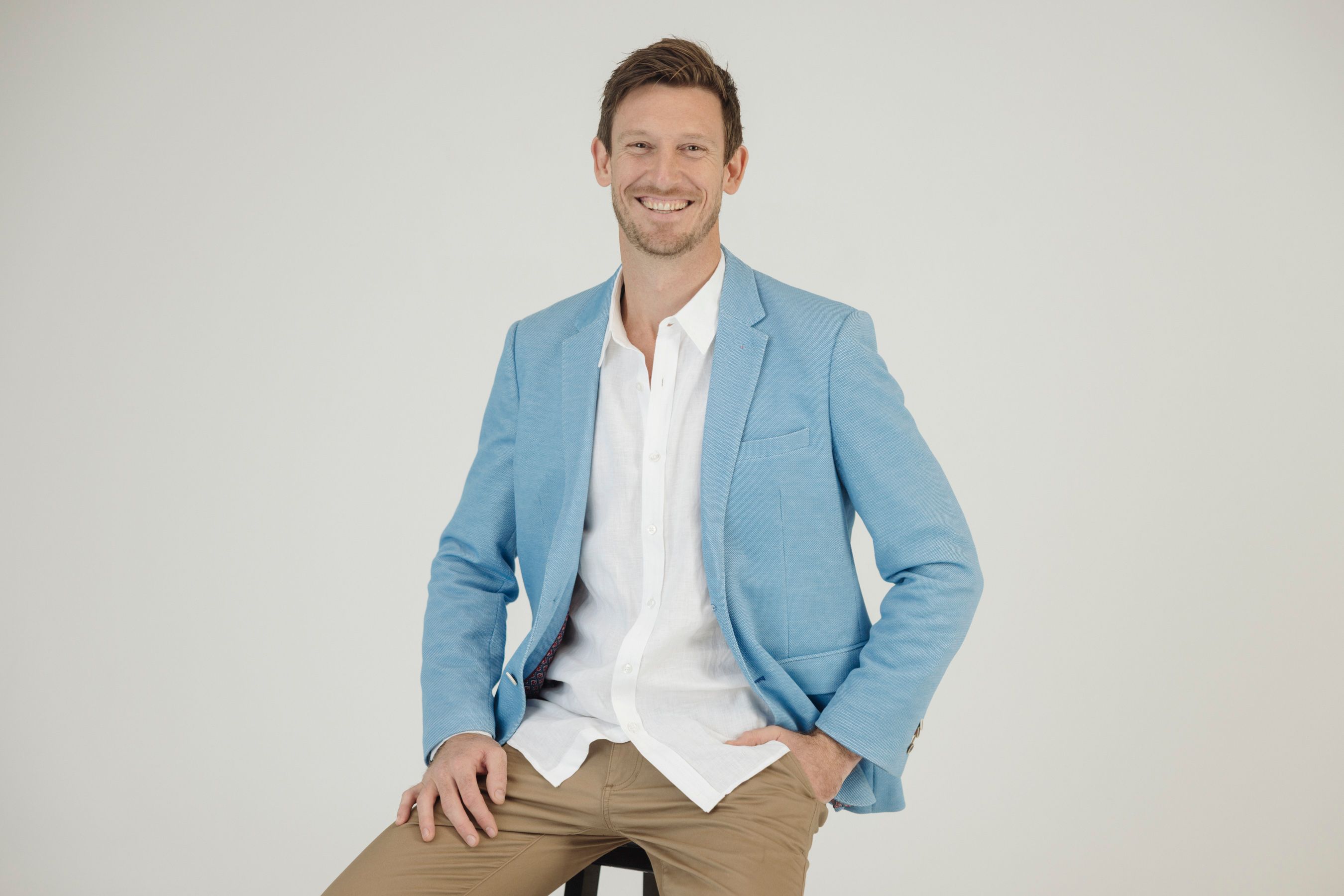 Mat Bankes seated in a light blue blazer, smiling